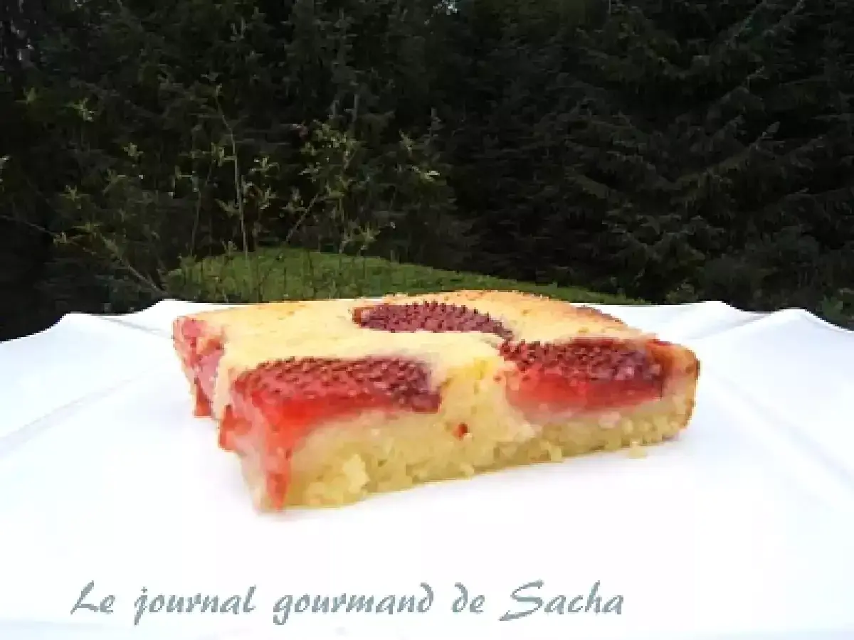 Un délicieux clafoutis aux fraises, tout juste sorti du four, sur une assiette blanche.