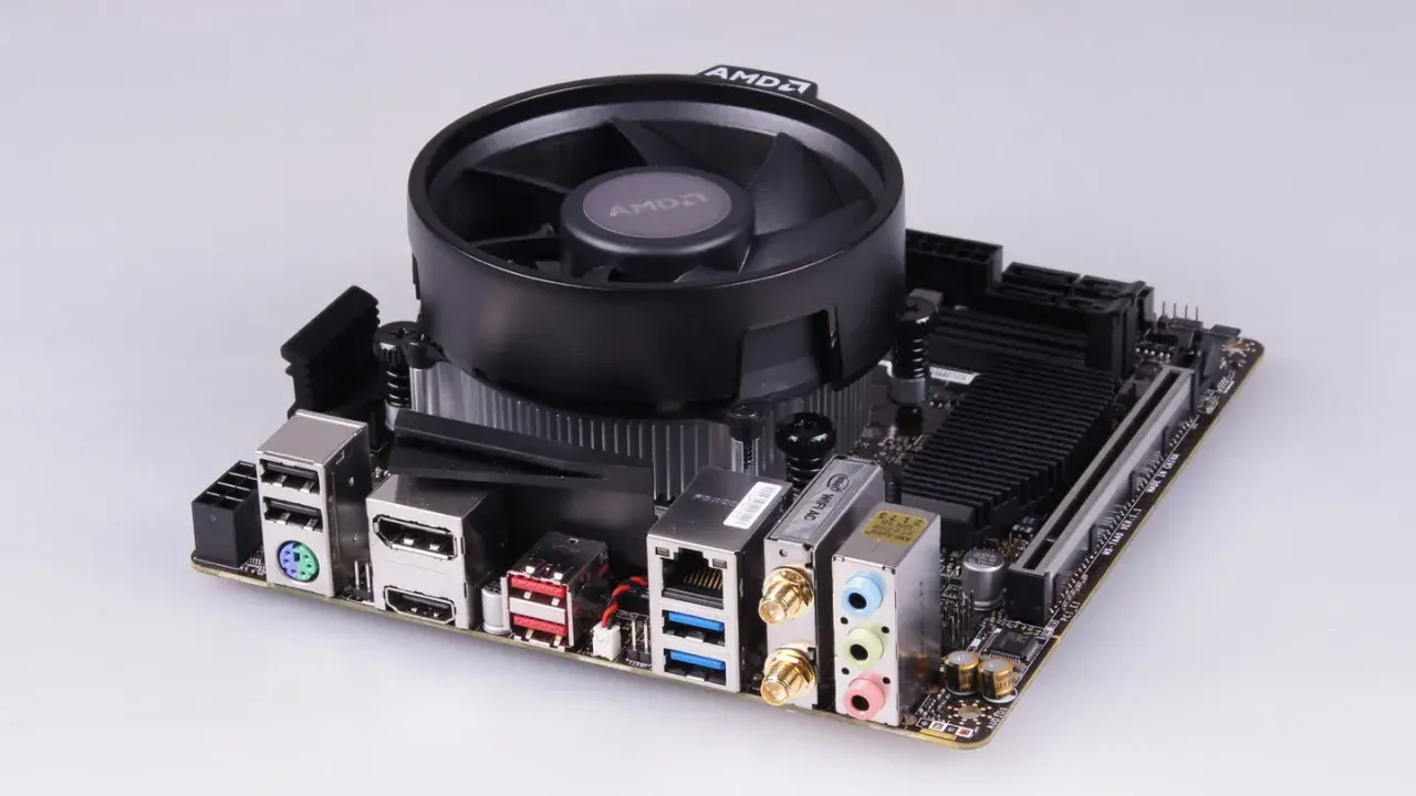 Mainboard mit AMD-Kühler, bereit für einen Ryzen 5 2400G Prozessor. Anschlüsse für USB, HDMI, LAN und Audio sind sichtbar.