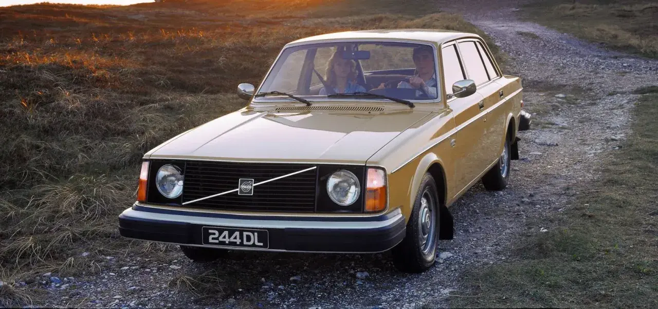En gul Volvo 244 DL kör på en grusväg i solnedgången. Hur många Volvo 240 tillverkades? Över 2,8 miljoner.