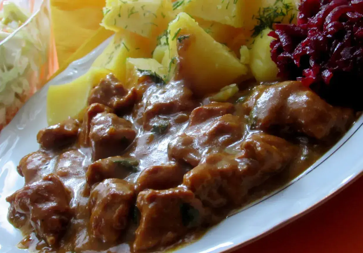 Gulasz z łopatki wieprzowej w sosie własnym, podany z ziemniakami i buraczkami. Pyszne, domowe danie.