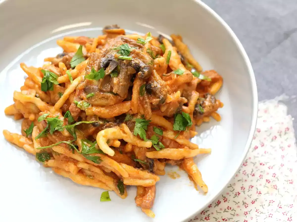 En krämig pasta boscaiola med svamp och persilja, serverad i en vit skål.