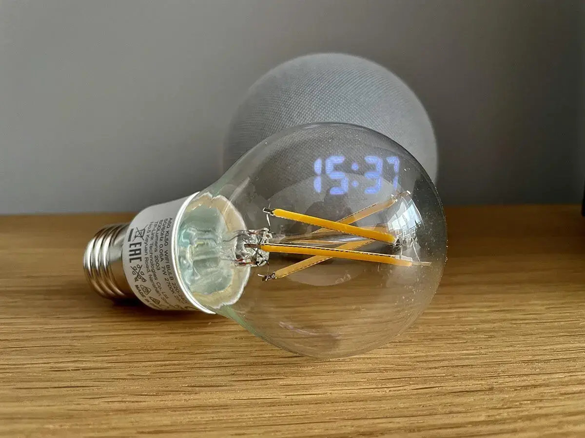 Bombilla inteligente con reloj digital y un dispositivo Echo Dot. Aprende como hacer que Alexa encienda la luz.