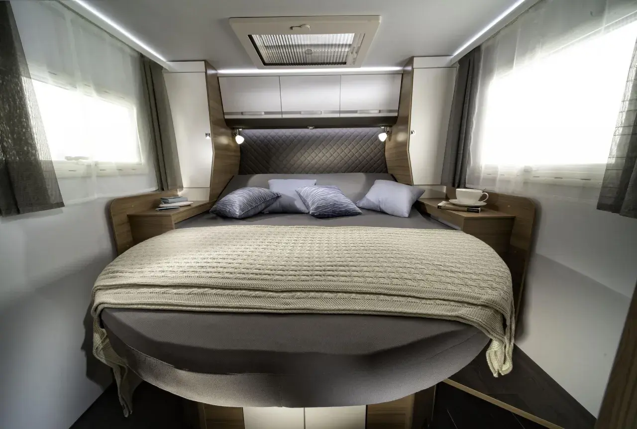 Lit transversal confortable dans un camping-car, prêt pour une nuit paisible.