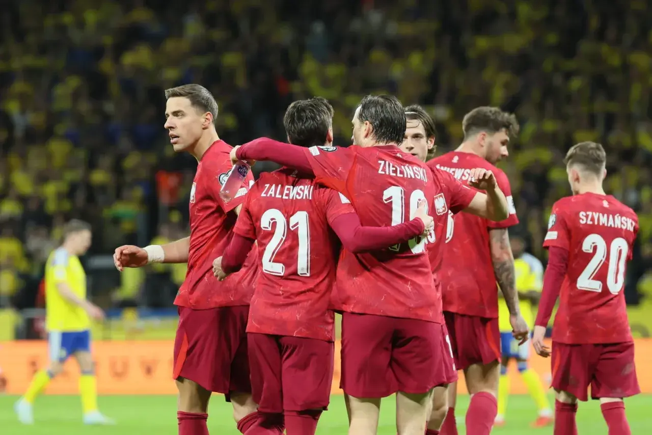 Piłkarze w czerwonych koszulkach świętują, czy polska jedzie na mundial? Zwycięstwo na boisku.