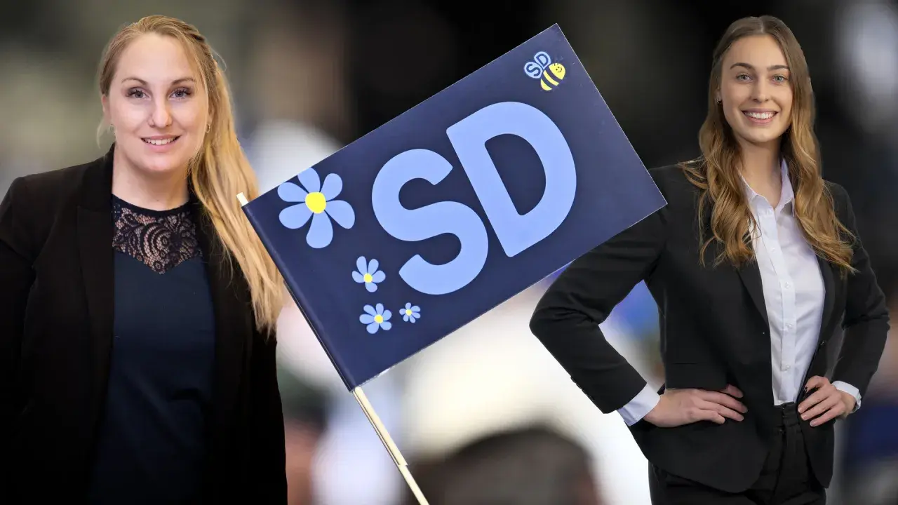 Två kvinnor med en SD-flagga. Bilden visar kvinnligt ledarskap och framtidstro.