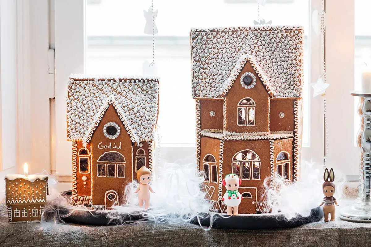 Två pepparkakshus med "God Jul" på det ena. Perfekt mall att skriva ut för att baka egna. Små figurer står framför.