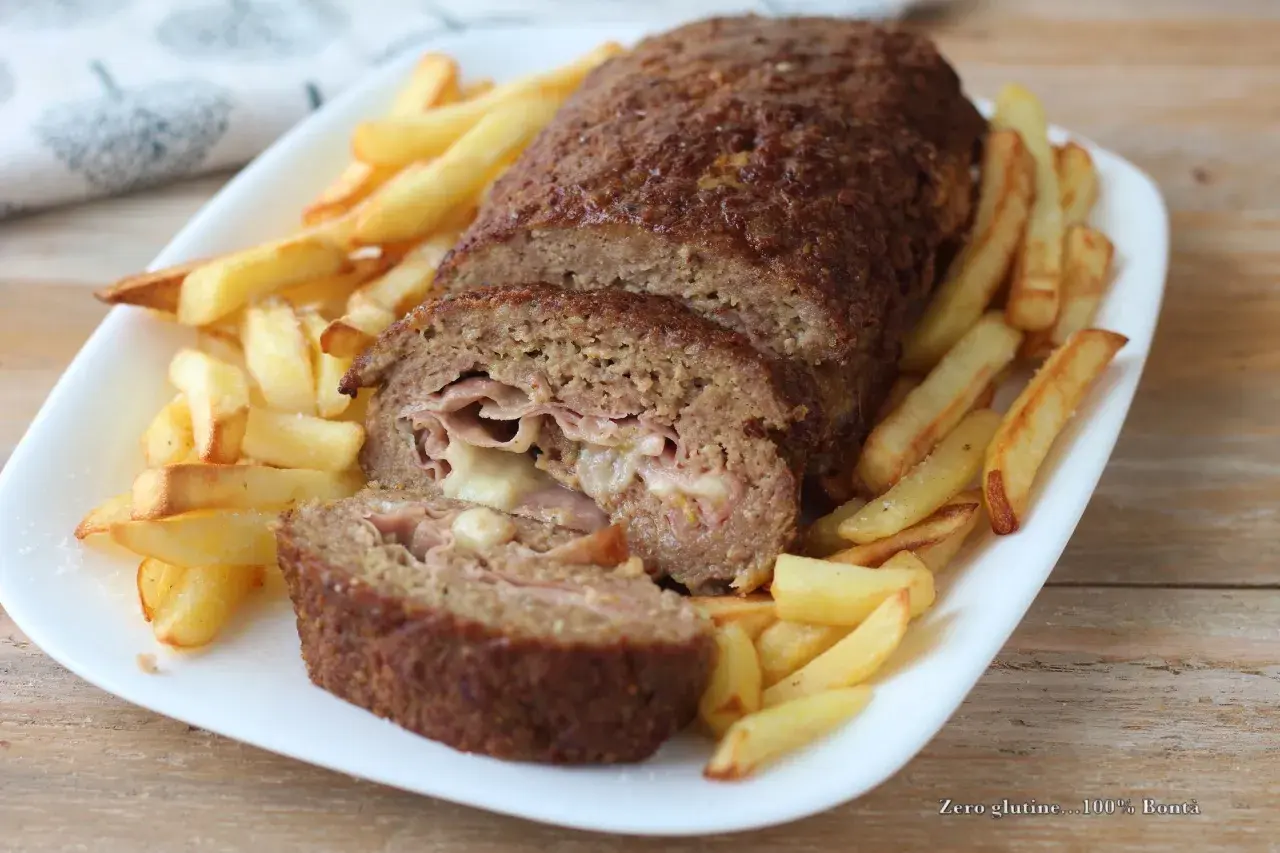 Polpettone ripieno di prosciutto e formaggio, cotto in friggitrice ad aria e servito con patatine fritte croccanti.