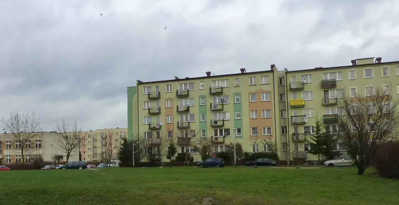 Bloki mieszkalne w Łodzi, z widocznym szyldem "SPRZEDAM". Ceny mieszkań w Łodzi mogą być różne, ale te budynki wyglądają na typowe dla osiedli z lat 70.