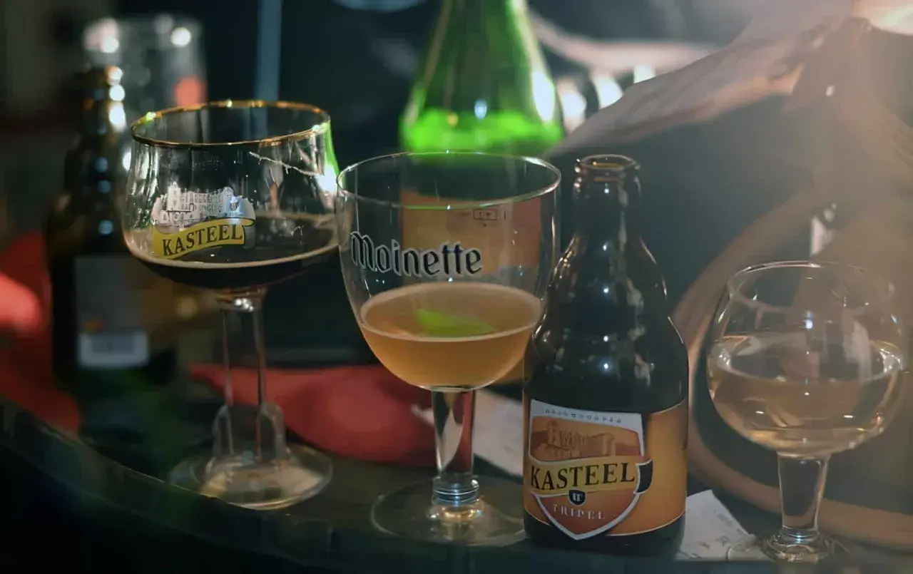 Dégustation de bières belges, dont une Kasteel Tripel, dans des verres emblématiques. Un aperçu de la richesse des bières de Bruxelles.