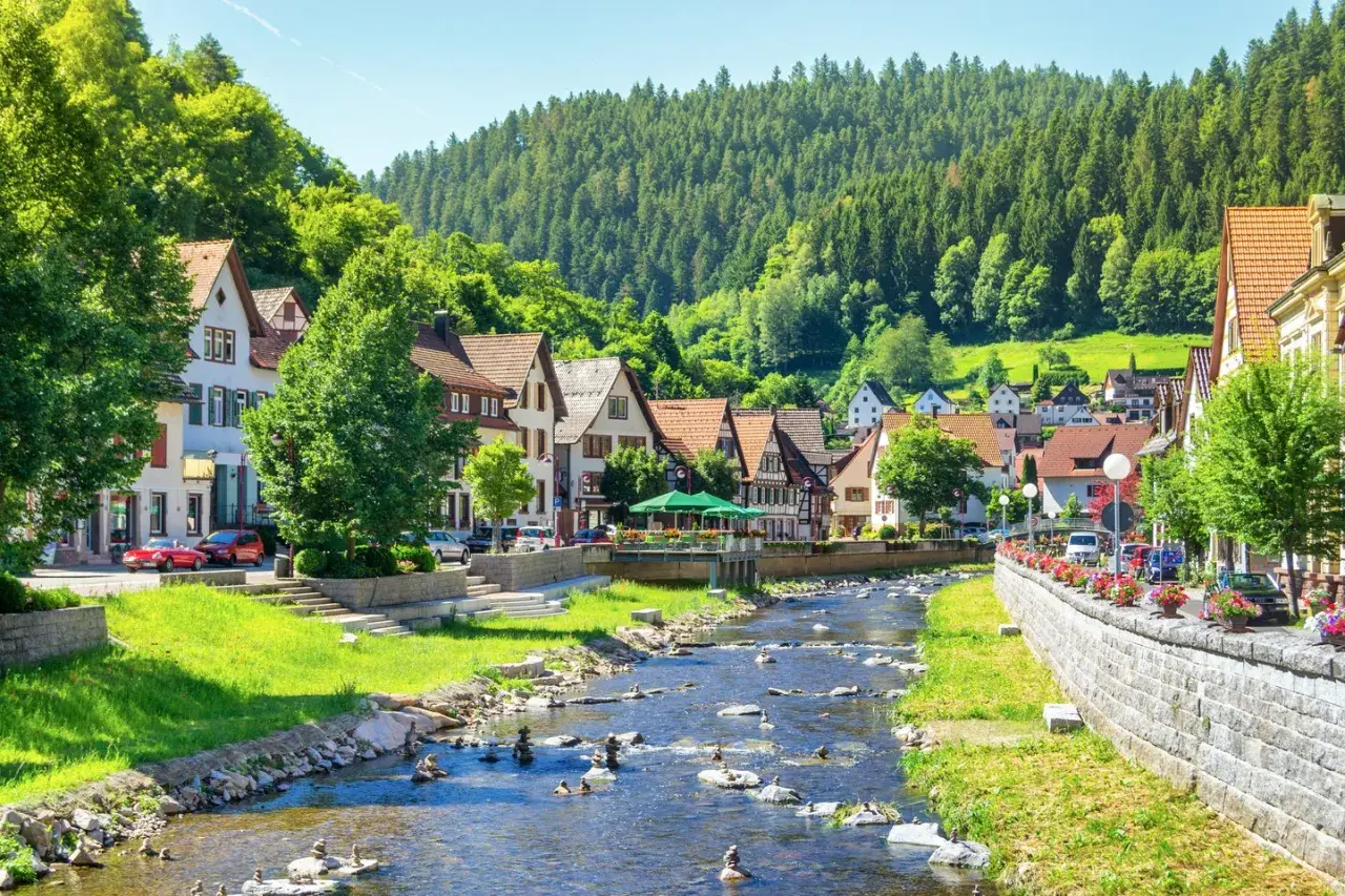 Idyllisches Dorf mit Fachwerkhäusern und einem Bach, perfekt für einen Urlaub ohne Auto.