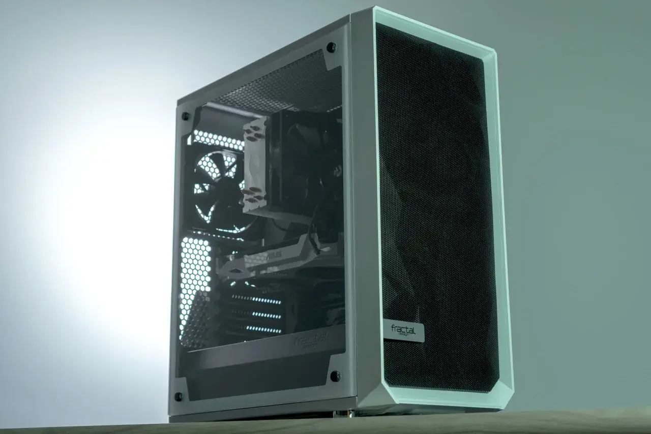 Boîtier PC blanc avec fenêtre latérale transparente, ventilateurs et carte graphique visibles. Le logo "fractal design" est présent. C'est quoi RGB ? Ce boîtier est prêt pour des lumières colorées.