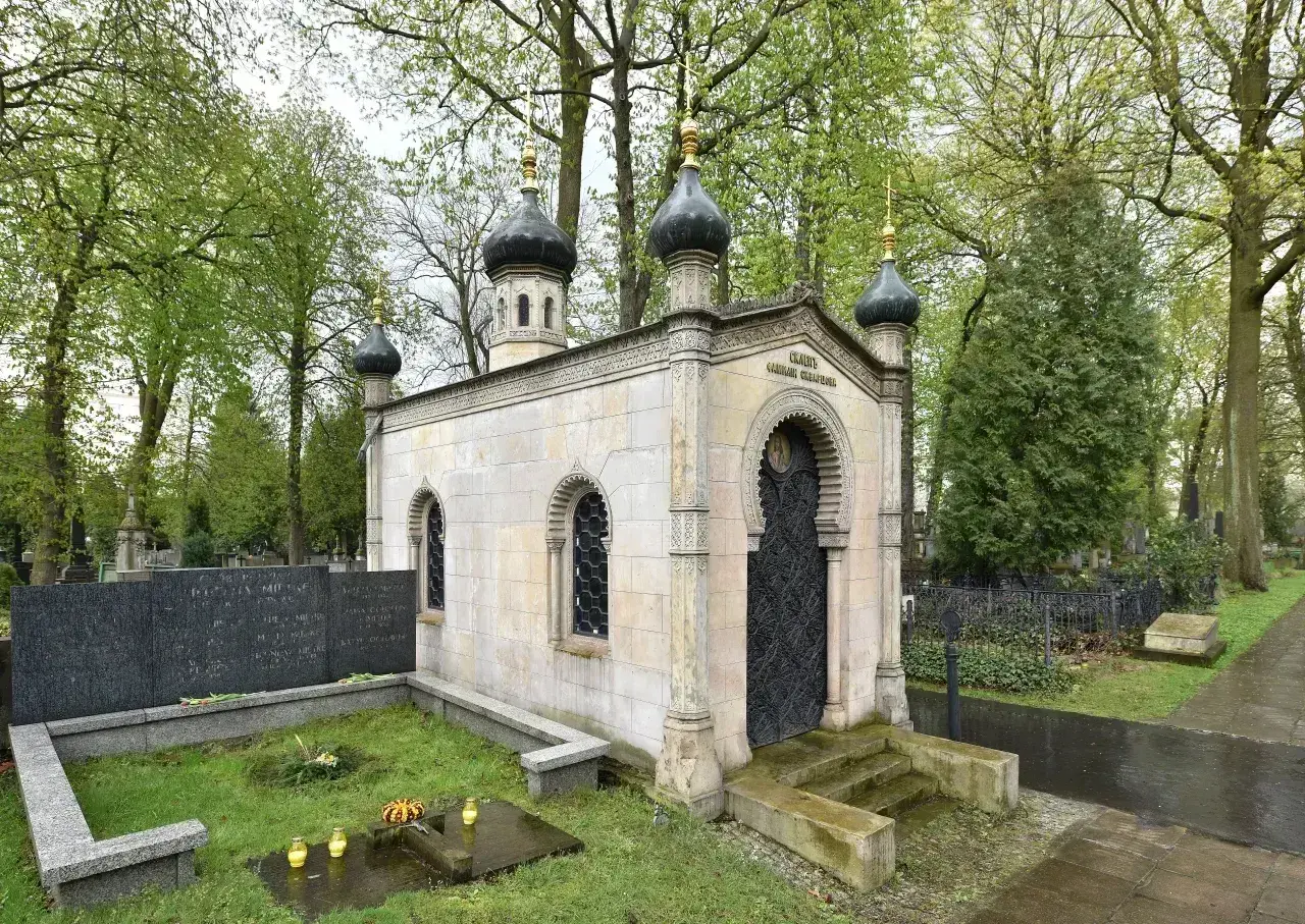 Kamienna kaplica z kopułami, ozdobnymi oknami i drzwiami, stanowi piękny grob.