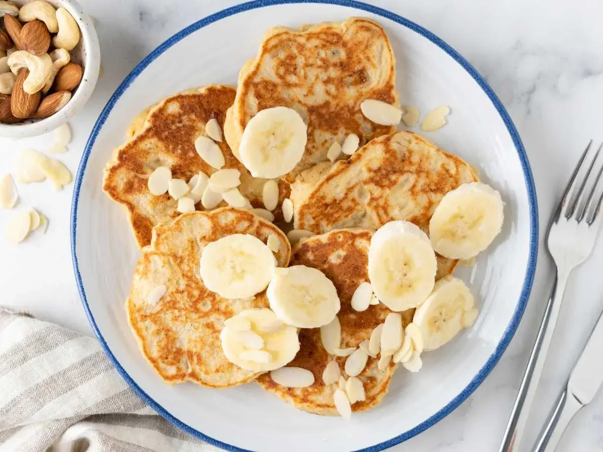 Deliciosas tortitas de plátano, adornadas con rodajas de plátano y almendras laminadas. Una receta perfecta para un desayuno o merienda.