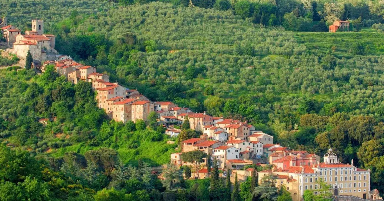 Antichi borghi vicino Pistoia si aggrappano alla collina, circondati da uliveti lussureggianti e vegetazione mediterranea.