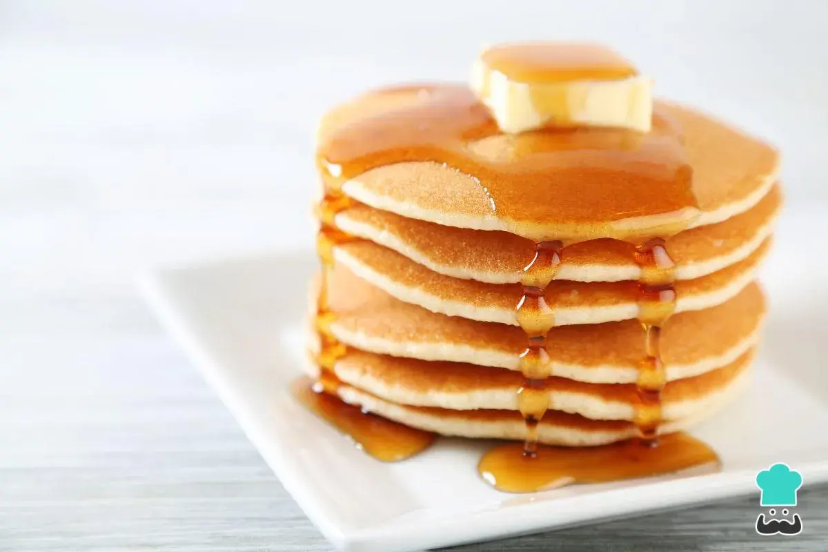 Pila de panqueques esponjosos con mantequilla y miel, perfecta para tu próxima receta.