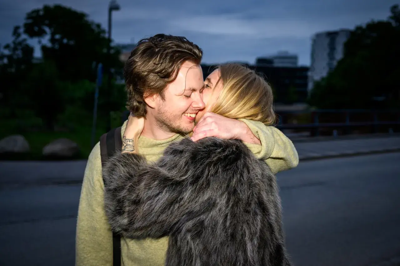 Amanda Romare och hennes lilleman omfamnar varandra lyckligt i skymningen.