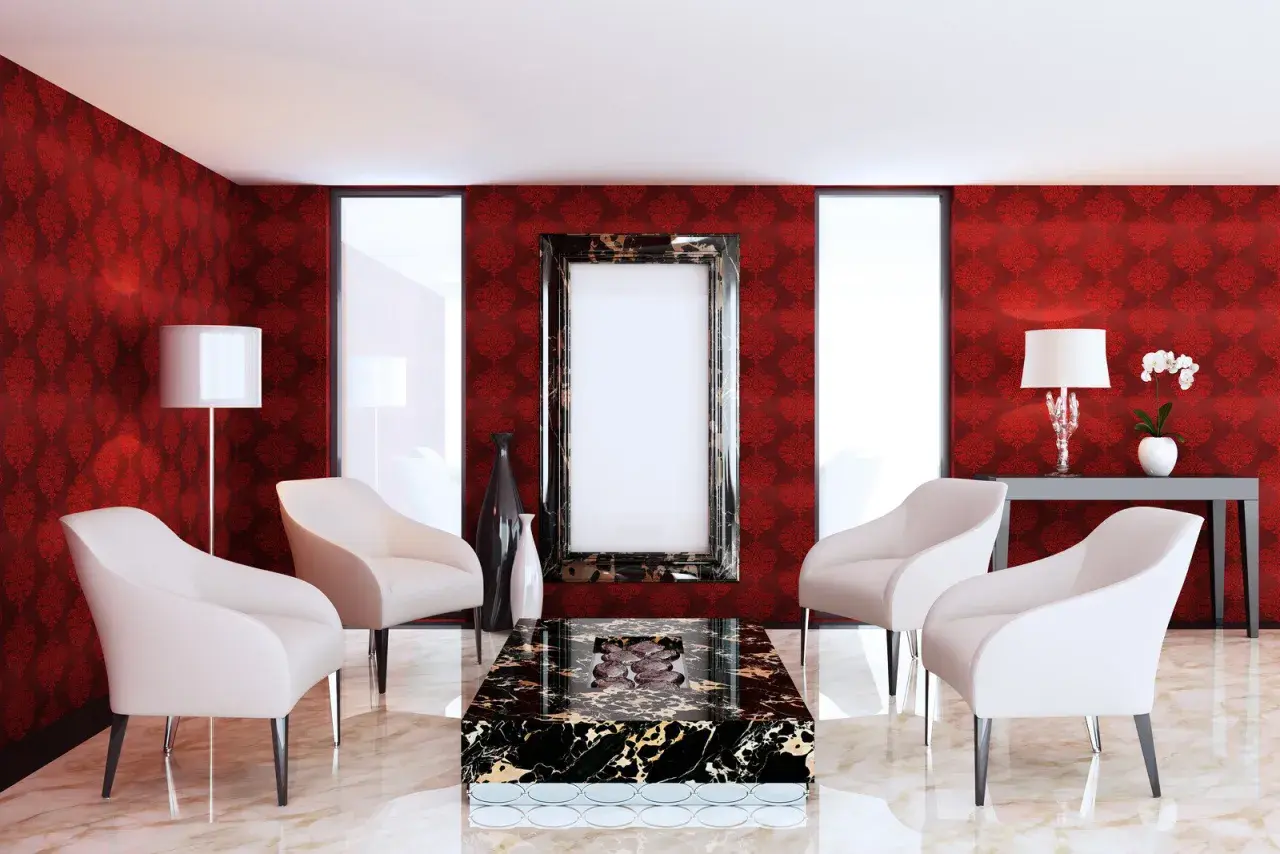 Elegancki salon z tapetą w ciemny czerwony kolor, białymi fotelami i marmurowym stolikiem.