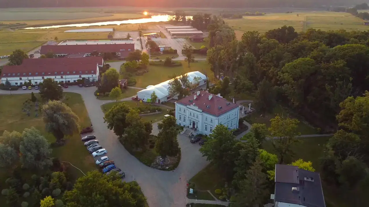 Widok z lotu ptaka na hotel Jakubus z otaczającym go parkiem i stawem w tle.