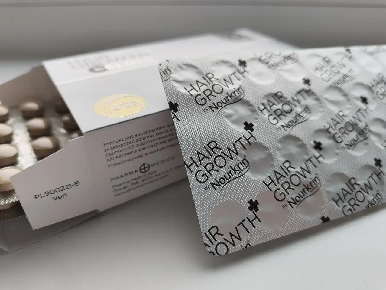 Suplement diety Nourkrin Hair Growth, zawierający proteoglikany na włosy, w blistrach i opakowaniu.