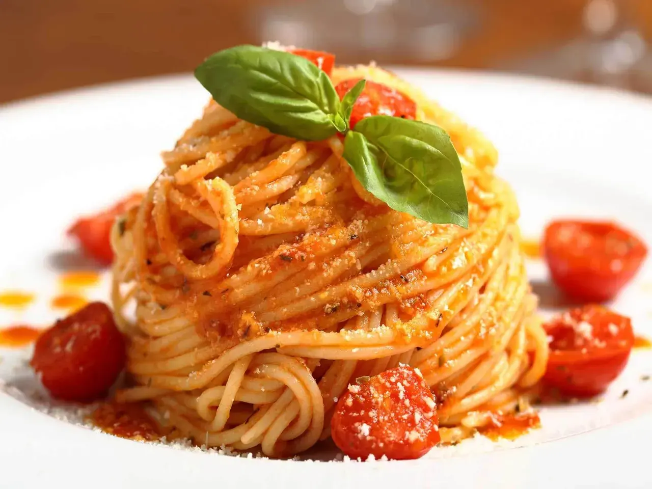 Ein Teller mit köstlichen Spaghetti Aglio e Olio, garniert mit frischem Basilikum und Kirschtomaten.