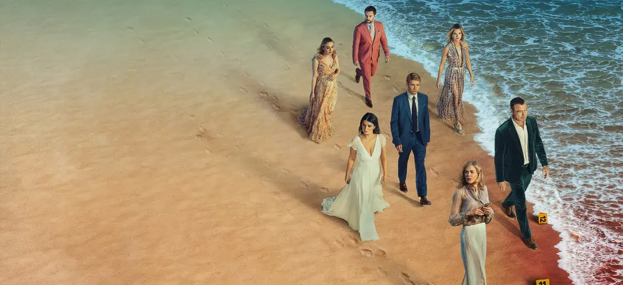 En grupp människor i eleganta kläder på en strand. Kanske är de det perfekta paret, eller så döljer de en hemlighet.
