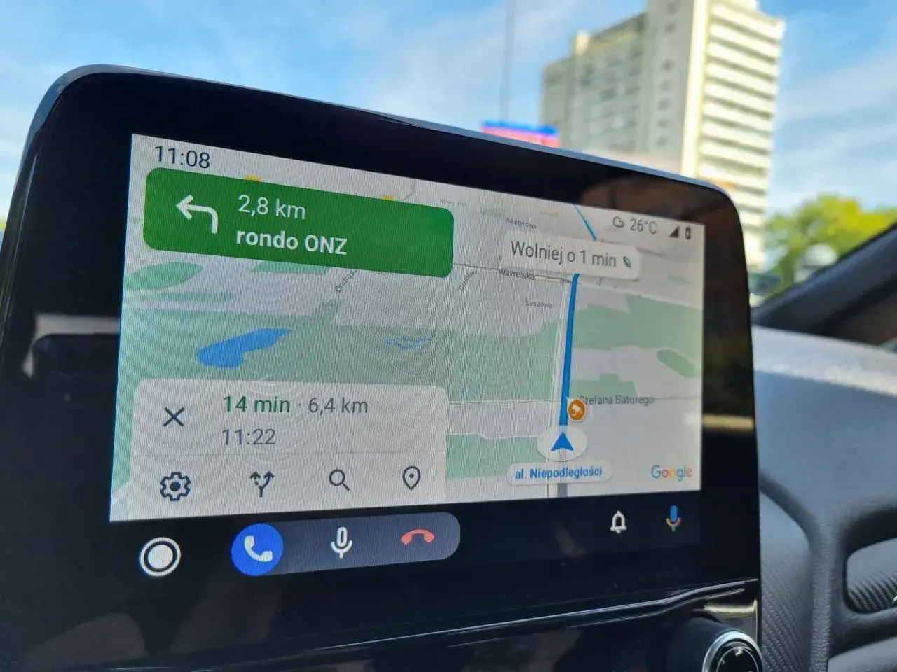 Nawigacja w samochodzie pokazuje trasę do ronda ONZ. Wyznaczanie azymutu na mapie jest kluczowe dla sprawnego dotarcia do celu.