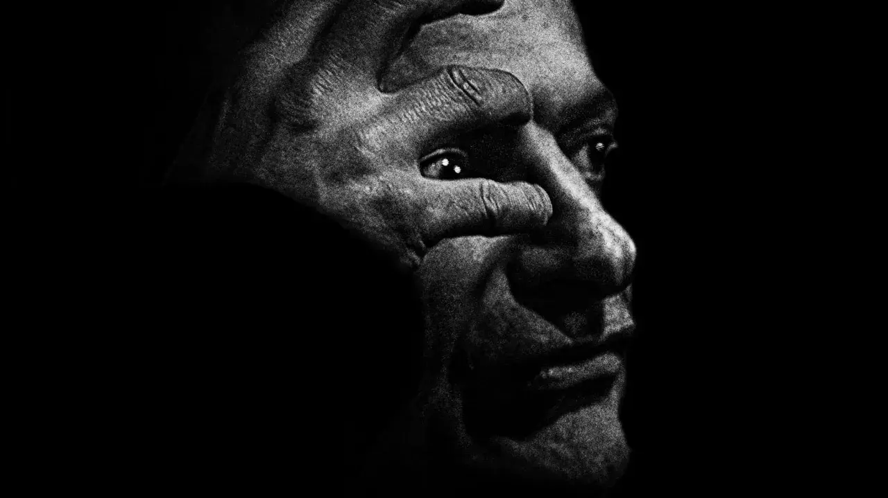 Intensywny portret w czerni i bieli, gdzie dłoń zakrywa oko, przywołuje mroczny styl antoine d'agata.