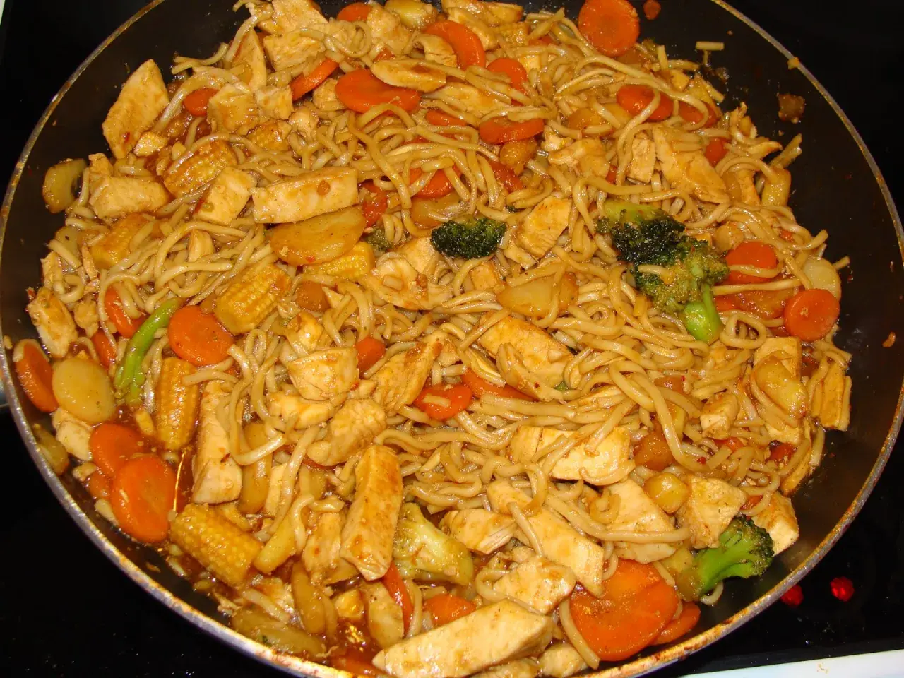 En smakrik kycklingwok med nudlar, morötter, broccoli och majskolvar i en härlig sås.