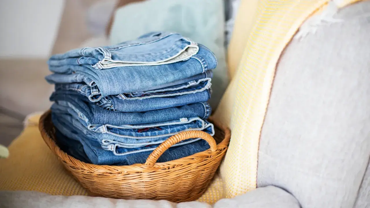 Stapel blauer Jeans in einem Korb. Die Frage, wie oft Jeans waschen, beschäftigt viele.