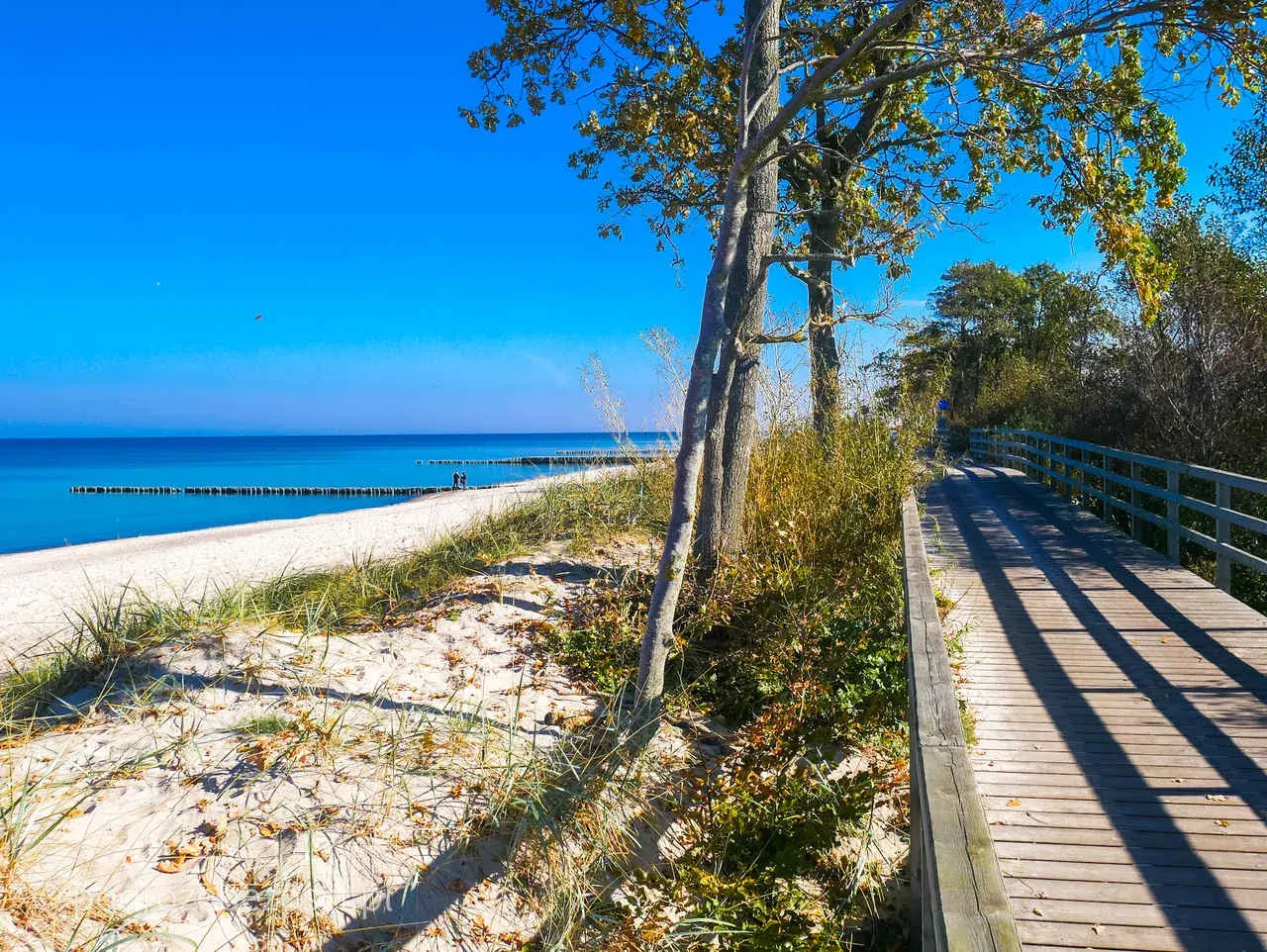 Drewniany deptak nad morzem w Kołobrzegu, idealne miejsce na spacer. Kołobrzeg atrakcje dla dorosłych to także piękne plaże i spokój.
