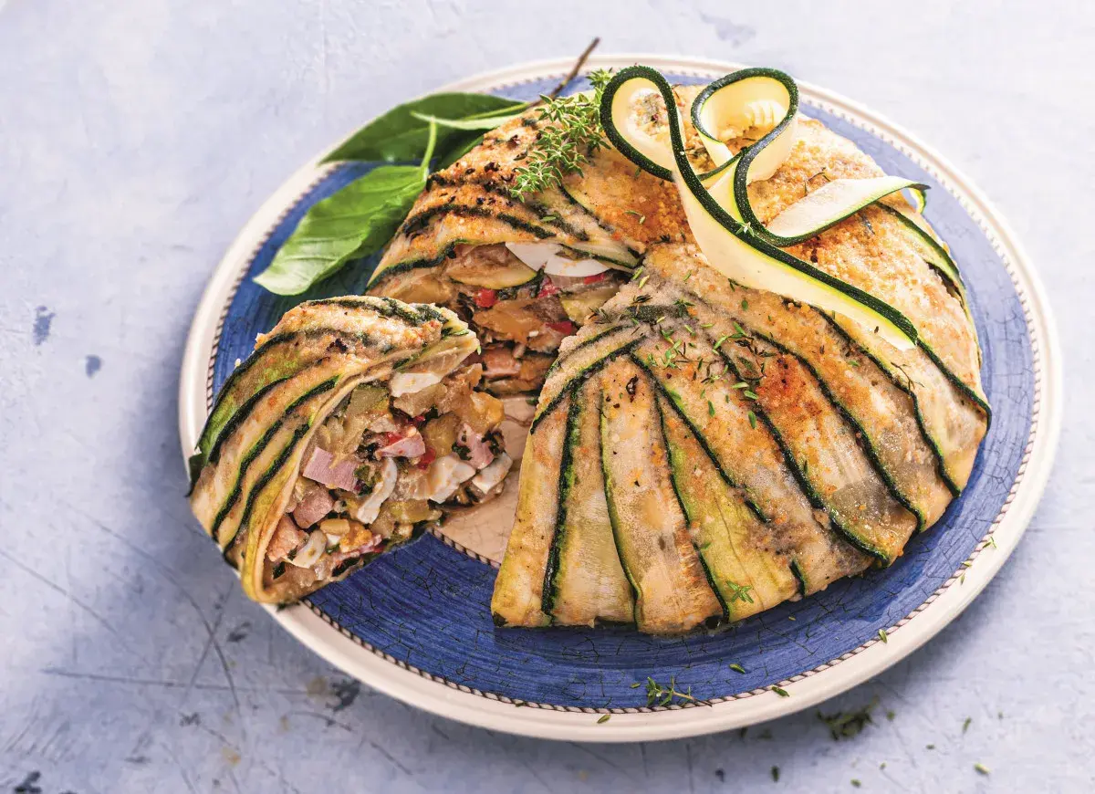 Babka z cukinii z warzywami i szynką, zapieczona w plastrach cukinii. Wygląda pysznie!