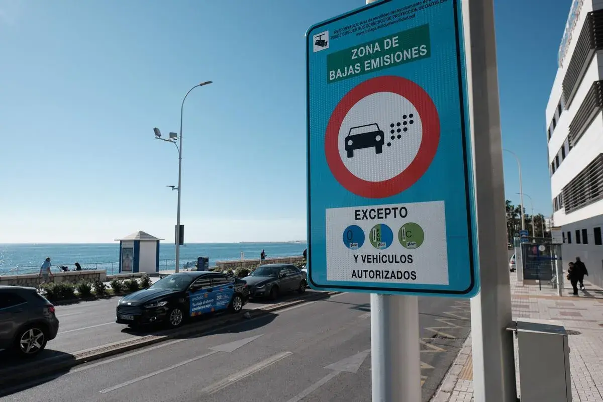 Señal de "Zona de Bajas Emisiones" (ZBE) con un coche y puntos de emisión. Indica excepciones para vehículos con distintivos C, ECO y 0.