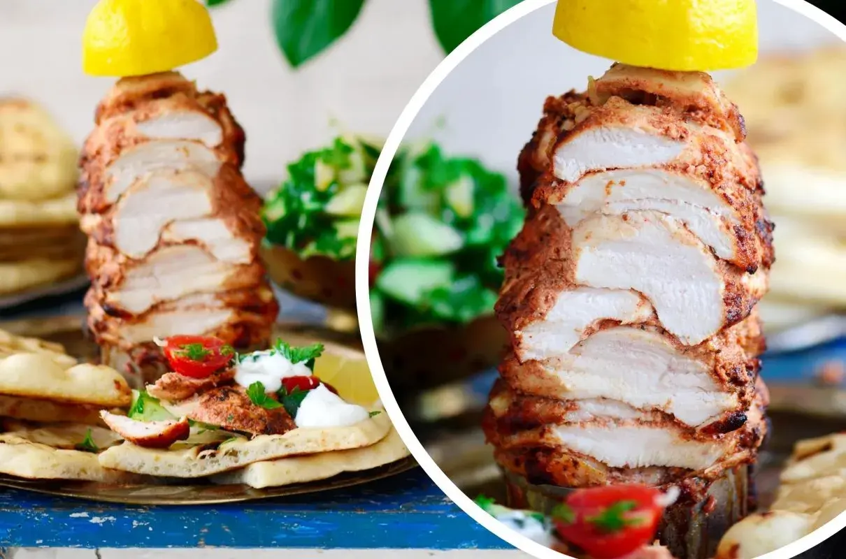 Soczysty kurczak döner na talerzu z pitą, pomidorkami i sałatką. Cytryna na wierzchu dodaje świeżości.