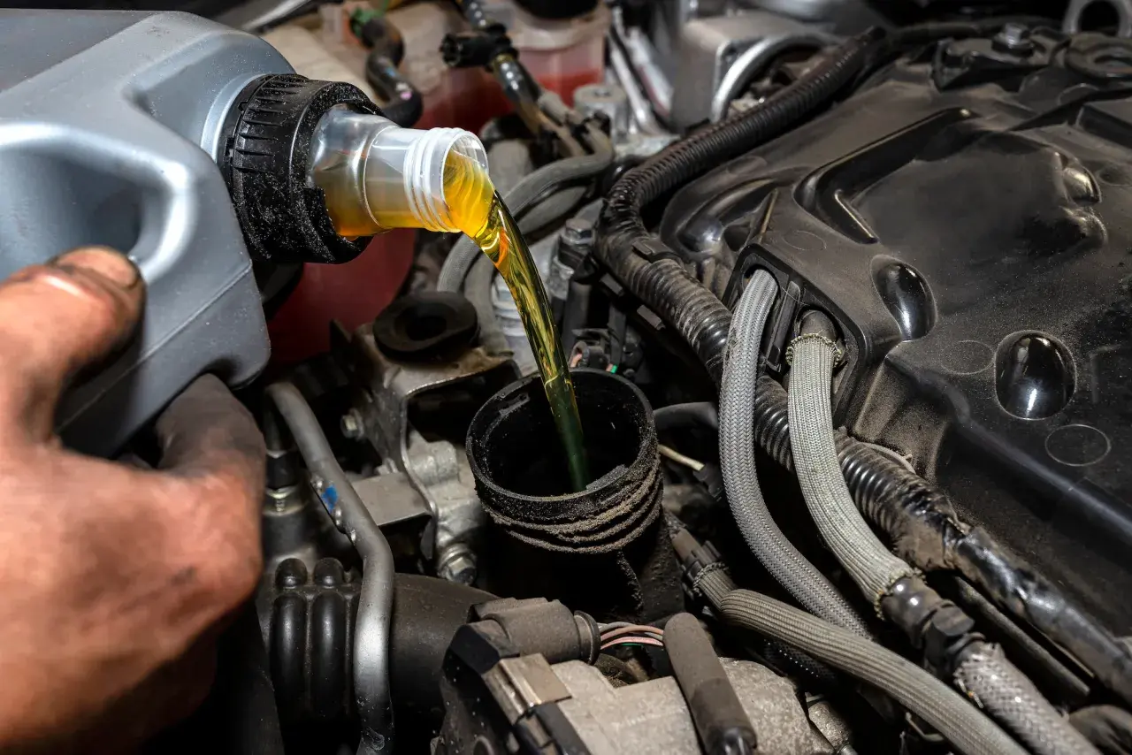Vertiendo aceite de motor, una tarea común al considerar la diferencia entre aceite 5w40 y 10w40.
