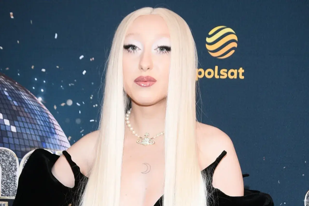 Luna w stylizacji na Eurowizję, z długimi blond włosami i perłowym naszyjnikiem.