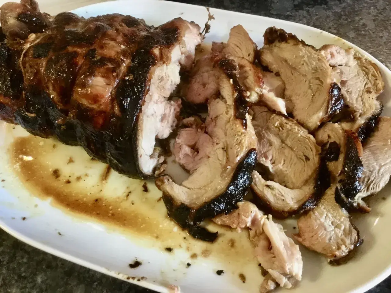 Épaule d'agneau au barbecue, parfaitement rôtie, avec une croûte caramélisée. Le temps de cuisson idéal pour cette pièce savoureuse.