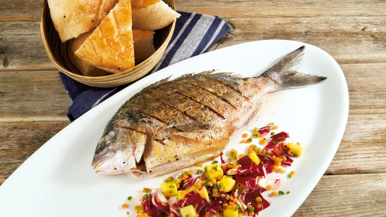 Gegrillte Dorade mit einem bunten Salat aus Radicchio, Linsen und Mango. Ein leichter Salat, der wunderbar zeigt, welcher Salat passt zu Dorade. Dazu gibt es frisches Brot.