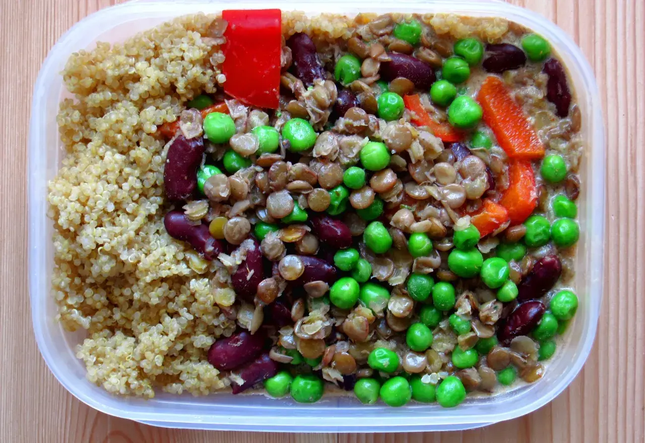En näringsrik vegetarisk matlåda med quinoa, linser, bönor, ärtor och paprika. Perfekt för en hälsosam lunch!