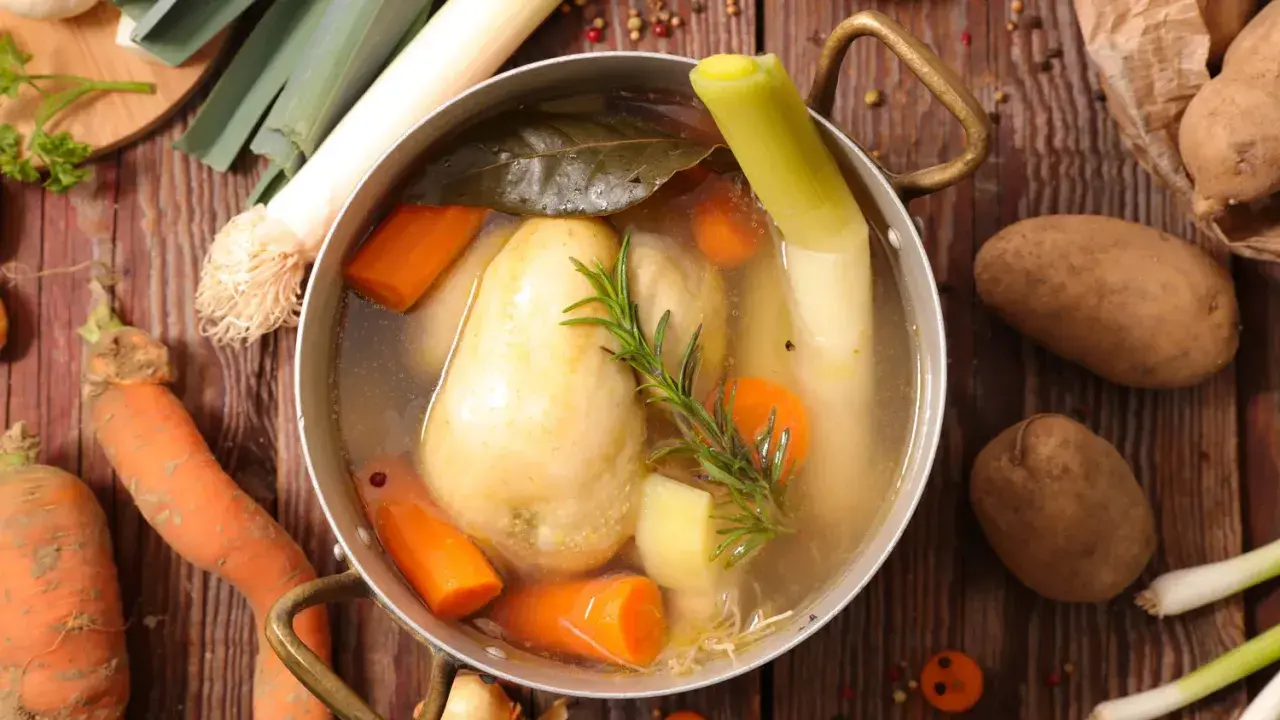 Un plat mijoté de poule au pot, avec carottes, poireaux et pommes de terre, prêt à être dégusté.