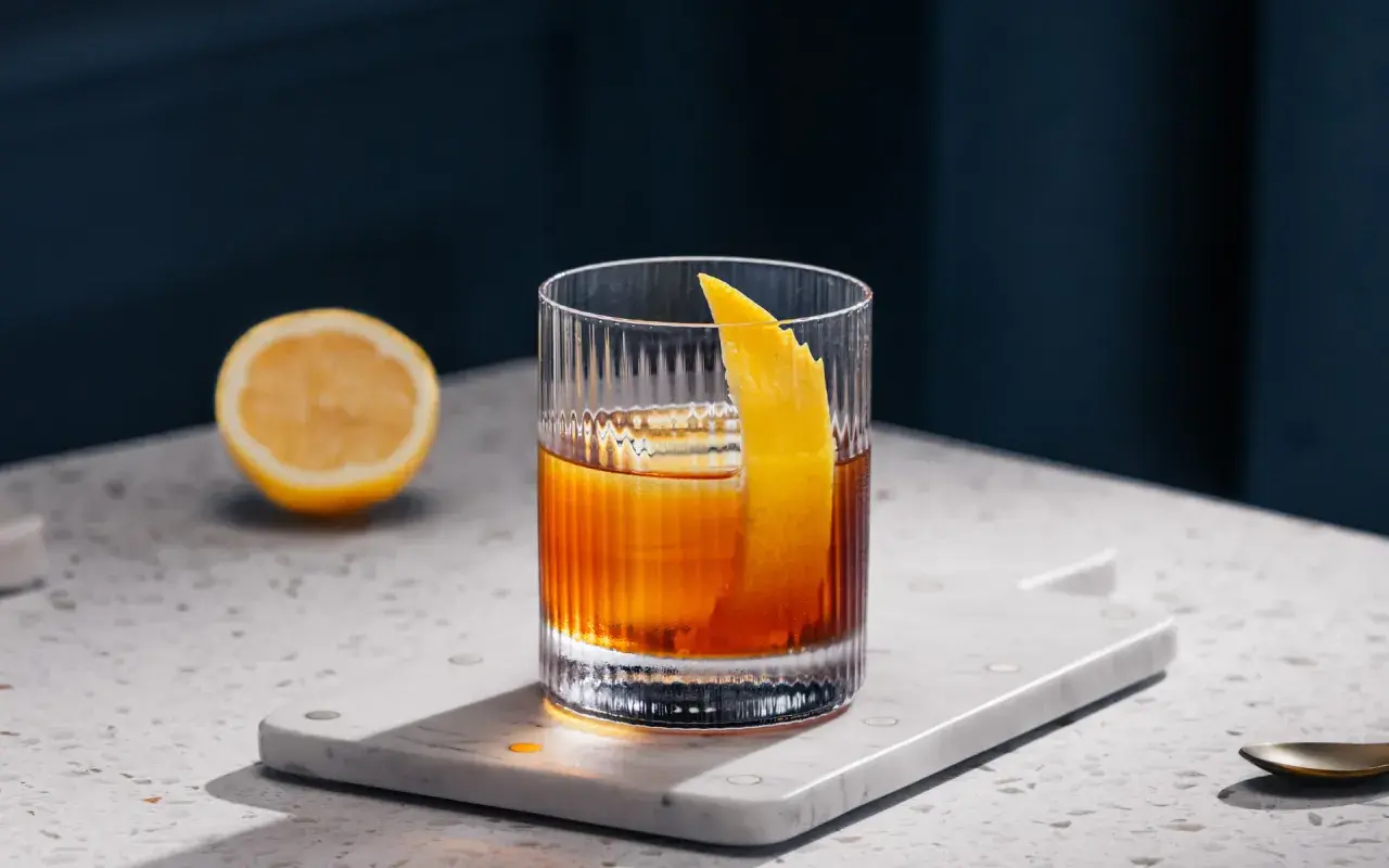 Klasyczne Old Fashioned z odpowiednią kostką lodu i skórką pomarańczy. Idealny drink na wieczór.