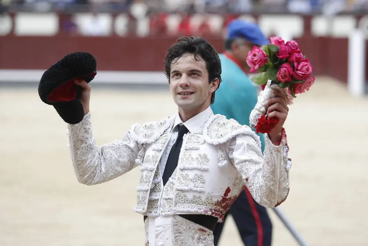 Juan del Álamo, torero, sonríe con un ramo de rosas en la mano y su montera en la otra, tras una faena.