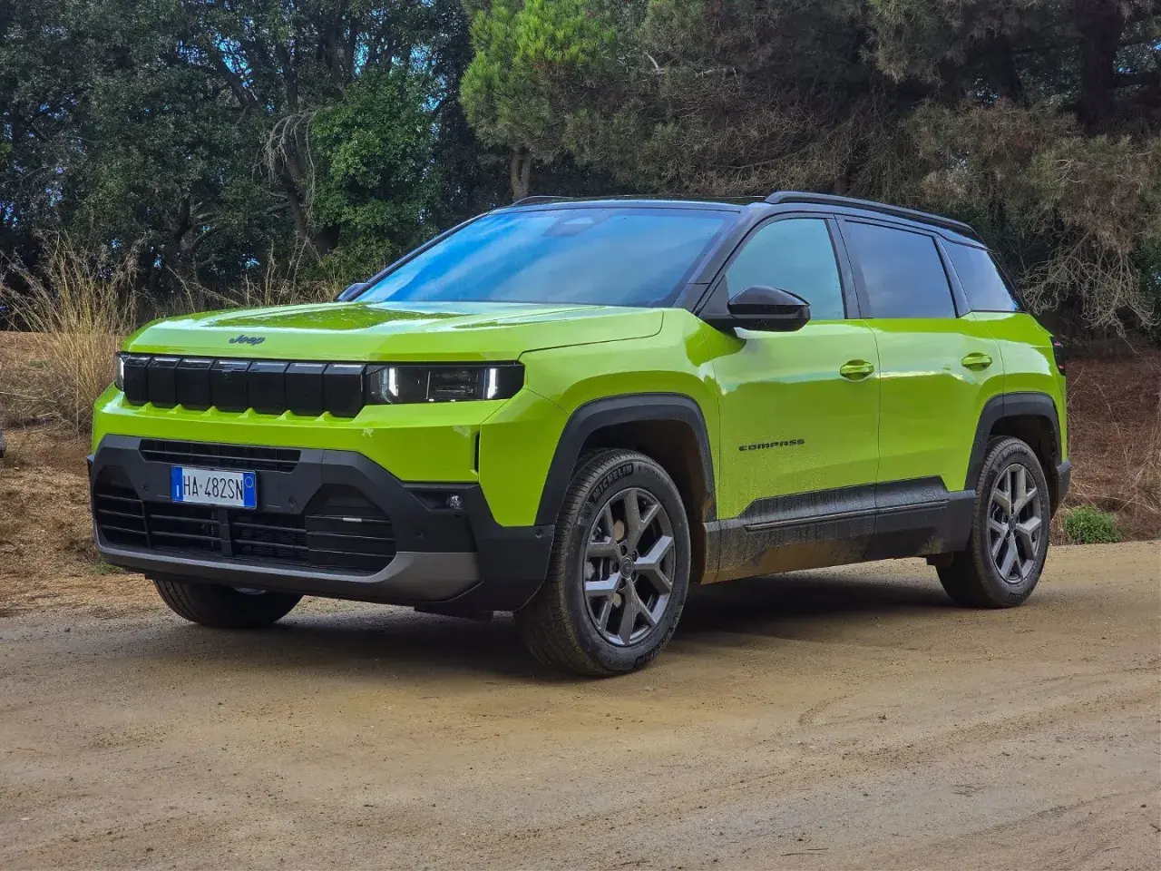 Jaskrawozielony Jeep Compass 2025 na drodze gruntowej, gotowy na przygodę.