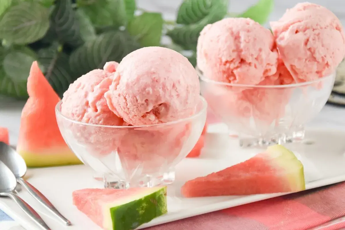 Dos copas de cremoso helado de sandía, decoradas con trozos de fruta fresca. ¡Un postre refrescante!