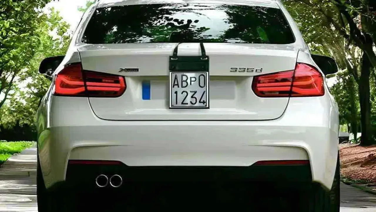 Parte posteriore di un'auto bianca con targa prova "ABPO 1234" appesa.