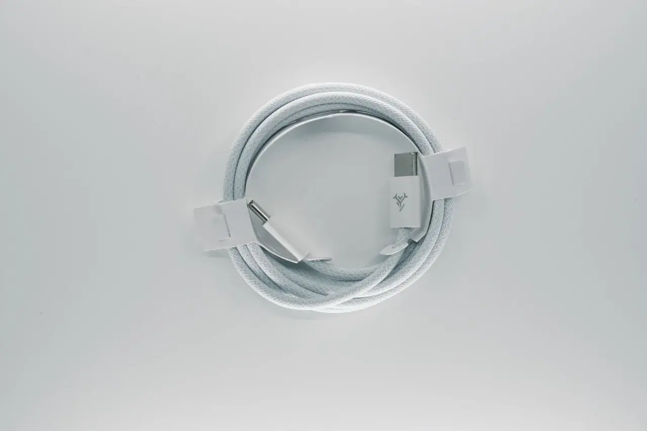 Biały kabel z końcówkami USB-C, zgodny ze standardem USB C, zwinięty na białym tle.
