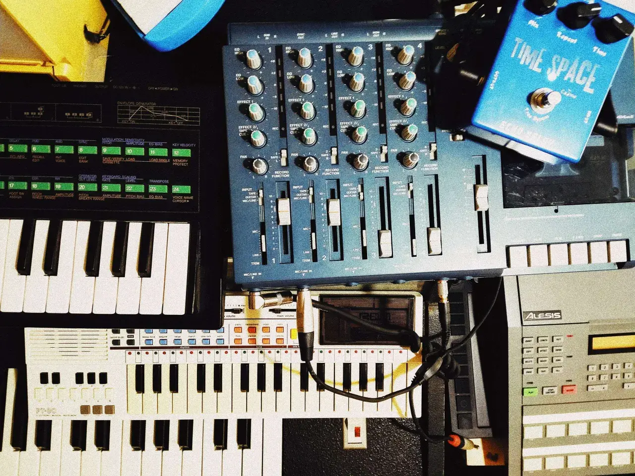 A musician's setup with keyboards, a mixer, and a blue "Time Space" pedal. This image shows how to clear sample data from a synthesizer.