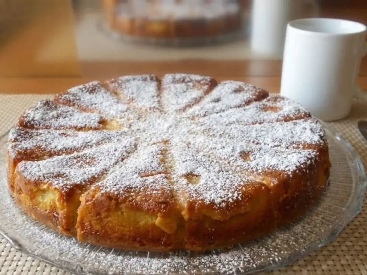 Gâteau mascarpone saupoudré de sucre glace, prêt à être dégusté avec une tasse de café.
