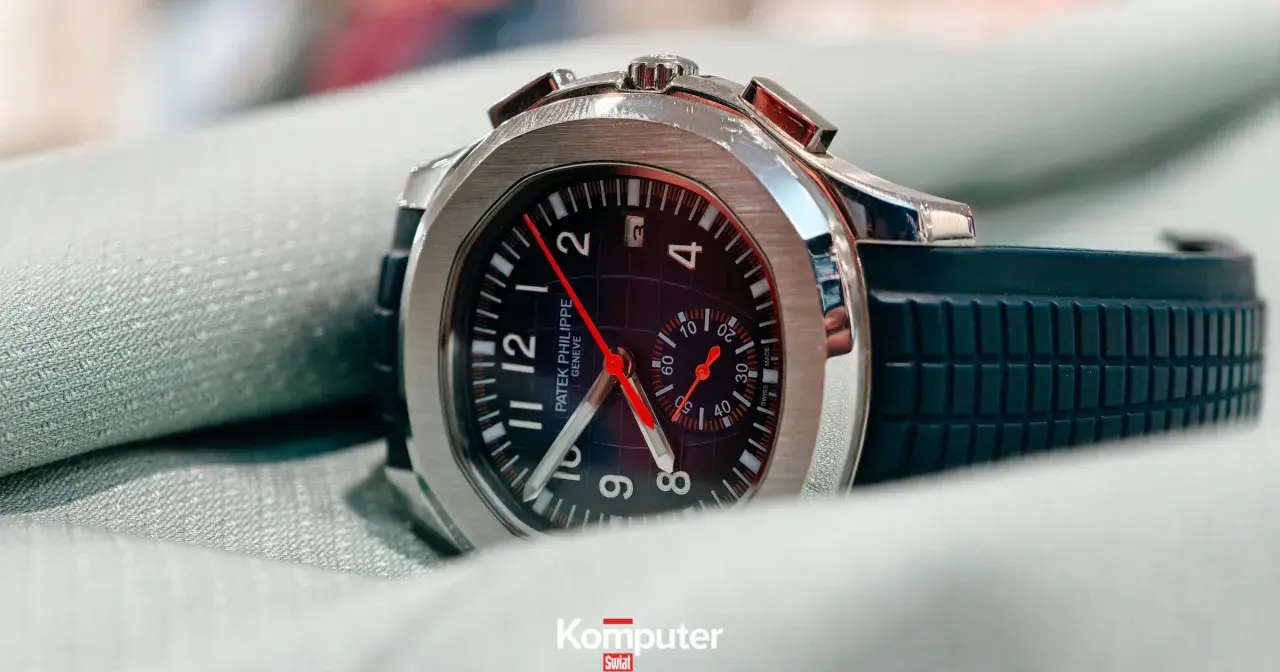 Elegancki zegarek Patek Philippe, model inspirowany stylem Marie Philippe, z czarną tarczą i gumowym paskiem, leży na zielonym materiale.