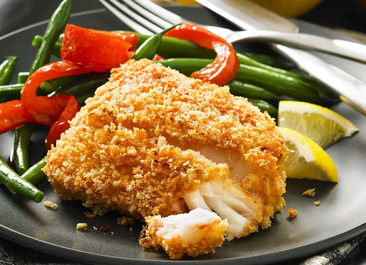 Chrupiący filet rybny w panierce panko z fasolką szparagową, papryką i cytryną.