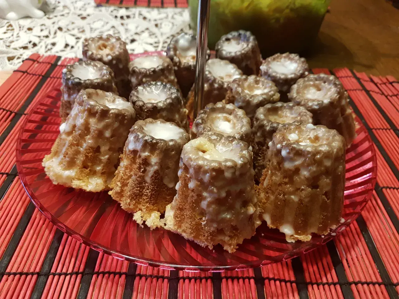 Mini babeczki piaskowe z lukrem na czerwonym talerzu. Idealne na deser, gdy masz ochotę na coś słodkiego.